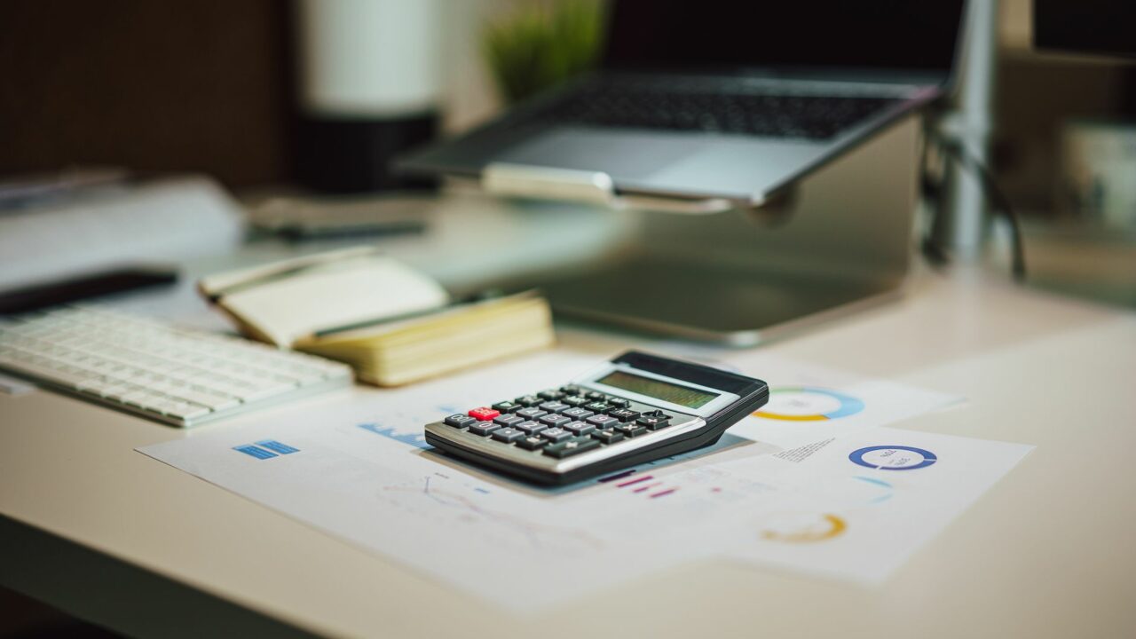 Bureau avec ordinateur, calculatrice et documents pour construire une allocation d'actifs