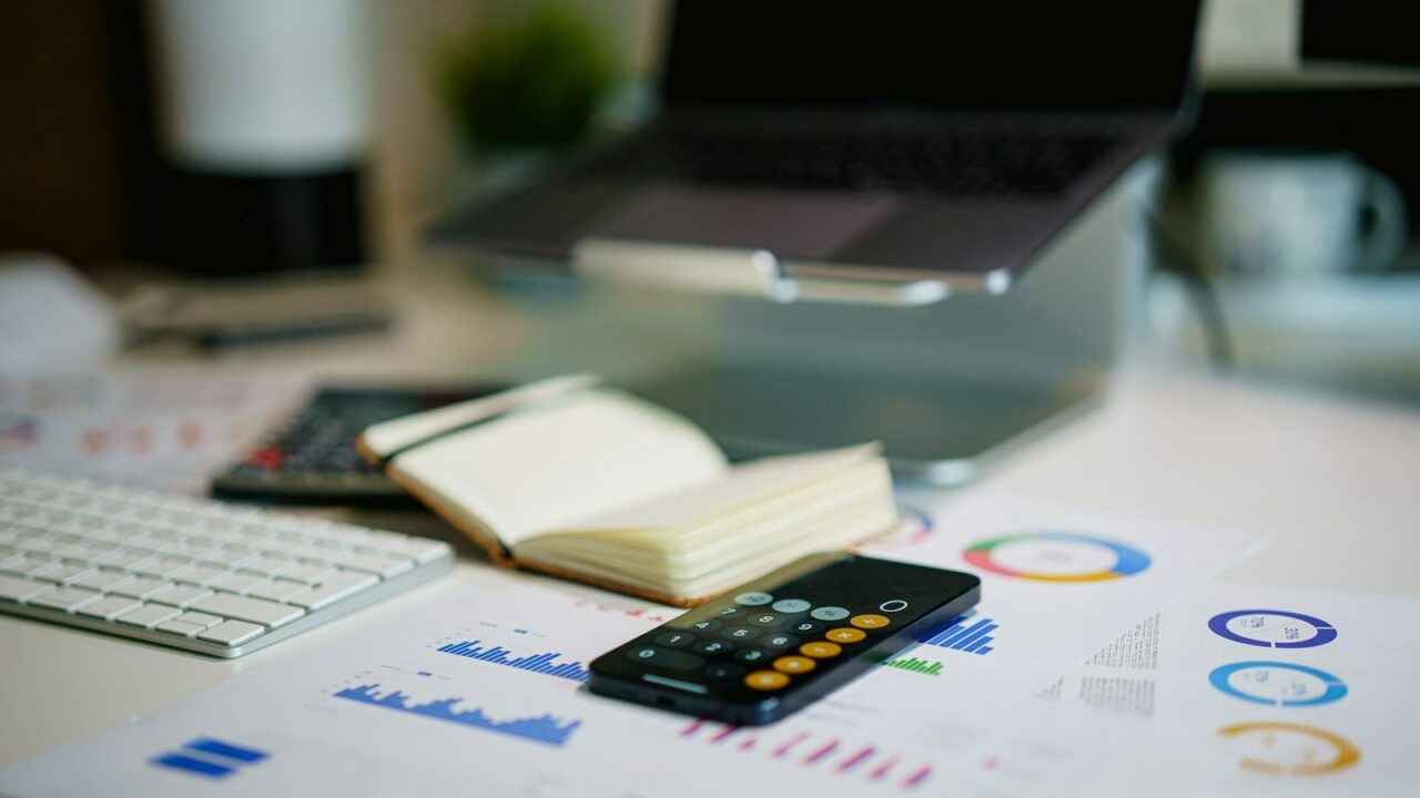 Bureau avec calculatrice, agenda et graphiques financiers pour le bilan patrimonial de fin d'année