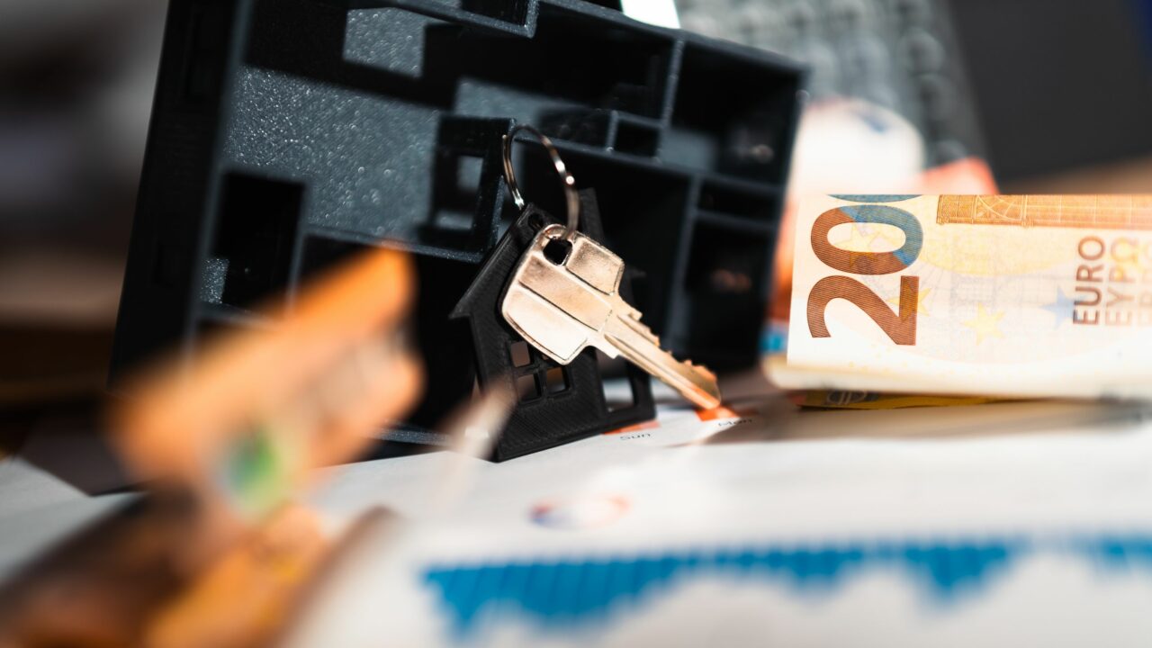 Clés, maquette de maison, billets en euros et graphiques symbolisant l'effet de levier immobilier