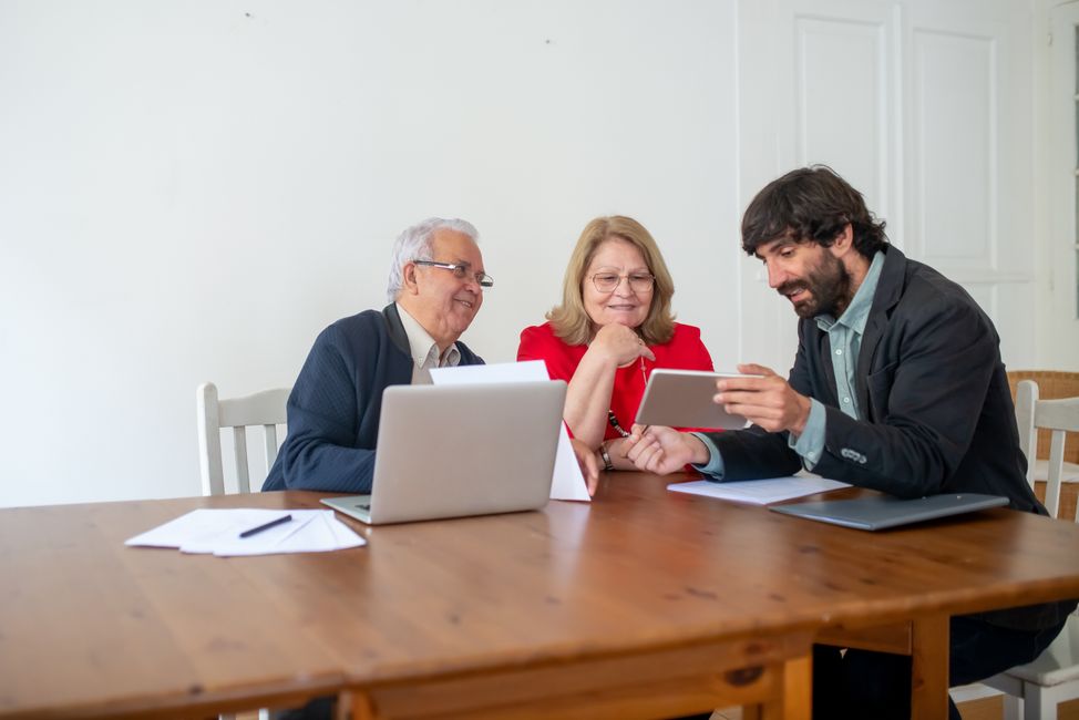 Deux investisseurs comparant PEA et assurance-vie avec leur conseiller autour d'un bureau