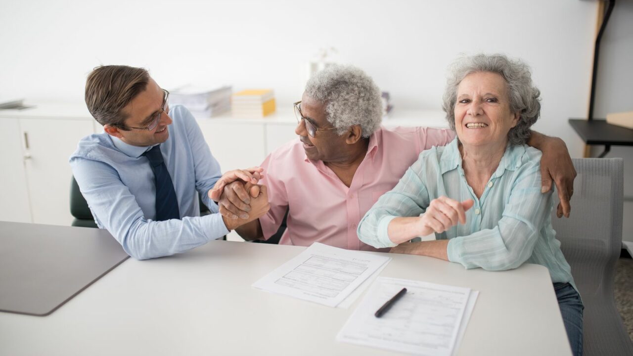 Couple senior en rendez-vous avec un conseiller financier pour la clause bénéficiaire de leur assurance vie